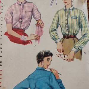 May include: A vintage sewing pattern featuring three different styles of blouses. The first blouse is pink and white gingham with a Peter Pan collar. The second blouse is yellow and green striped with a white collar. The third blouse is blue with a button-down collar. The pattern includes instructions for sizes 14 and 32.