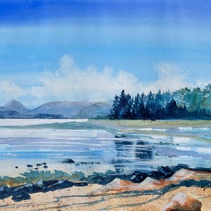 May include: Watercolor painting of a serene landscape featuring a body of water, mountains, and a blue sky with clouds. The foreground shows a rocky shoreline and sandy beach. Trees line the water's edge.
