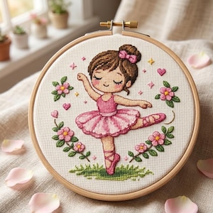 Pode incluir: Um bastidor de bordado em ponto cruz com uma bailarina em tutu rosa e sapatilhas de ballet. O design inclui flores rosas, corações e estrelas sobre um fundo branco. O bastidor de madeira é uma charmosa obra de arte feita à mão.