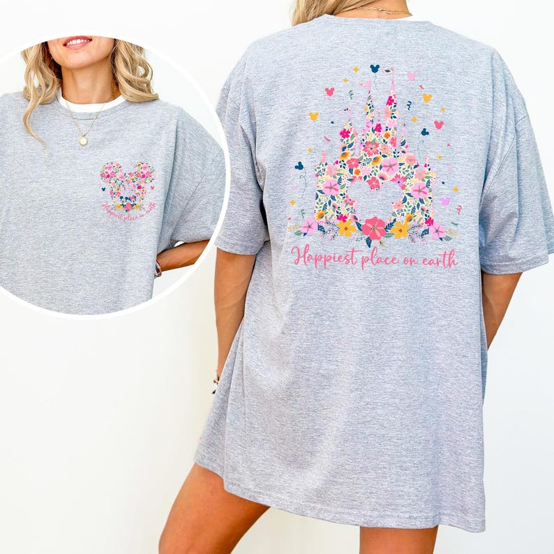 May include: Gray t-shirt with a floral castle design on the back and a smaller floral design on the front. The back of the shirt has the text "Happiest place on earth" in pink script. The front design is a floral Mickey Mouse head.