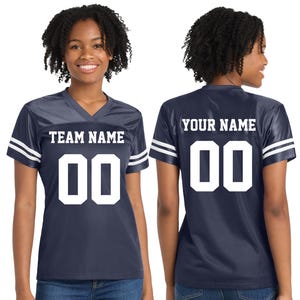Może przedstawiać: Granatowa koszulka do futbolu z białymi paskami na rękawach. Prz&oacute;d koszulki wyświetla napis "TEAM NAME" nad białym numerem "00". Tył koszulki pokazuje "YOUR NAME" nad numerem "00".
