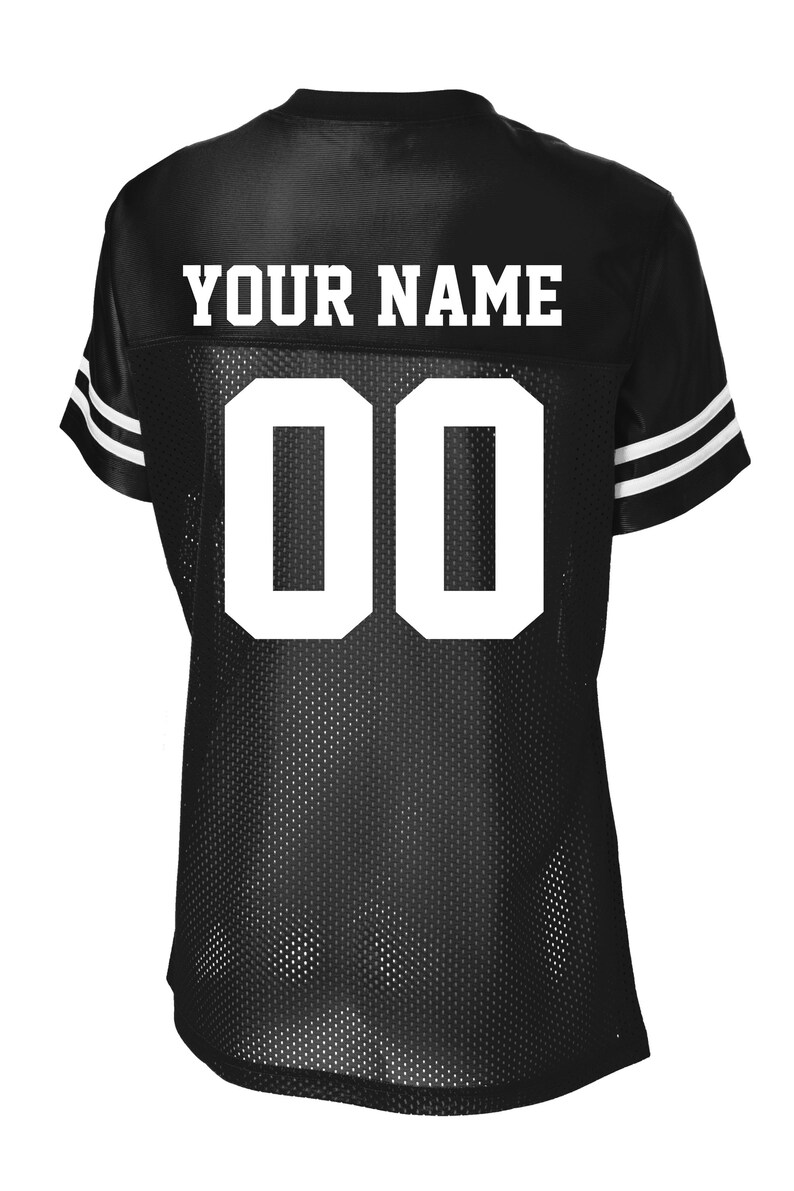 Może przedstawiać: Czarna koszulka z siatki z białymi literami i cyframi. Tekst "YOUR NAME" znajduje się na g&oacute;rnej części plec&oacute;w. Numer "00" jest wyśrodkowany na plecach. Białe paski zdobią rękawy.