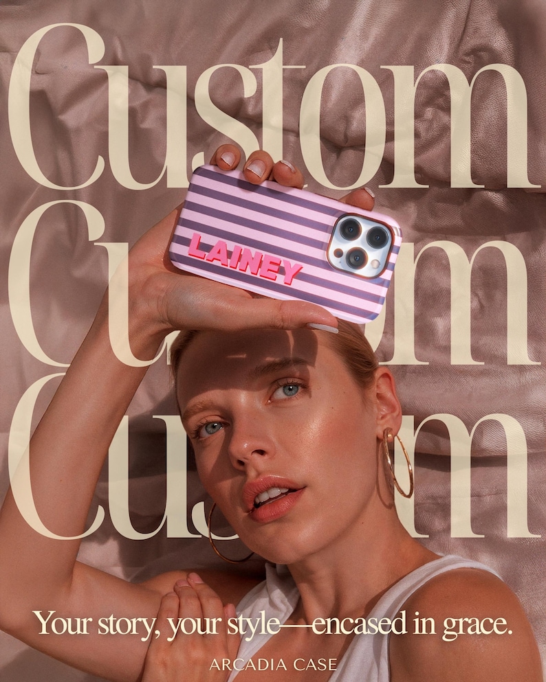 May include: A custom phone case with a pink and purple striped design, featuring the name "LAINEY" in pink letters. The case is held up in front of a person. The text "Your story, your style&mdash;encased in grace" is visible.