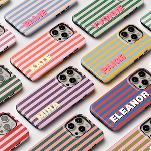 May include: A collection of colorful phone cases with vertical stripes in various colors, including pink, green, and blue. Each case features a name in a contrasting color, such as "Kate" or "Eleanor". The cases are designed to fit a smartphone.