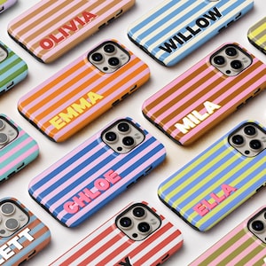 May include: A collection of colorful phone cases with horizontal stripes in various colors, including pink, blue, orange, and green. Each case features a name in a contrasting color, such as "Olivia" or "Willow". The cases are designed for a smartphone.