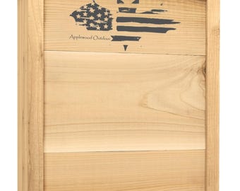 May include: A wooden bat house with a natural finish. The front panel features a dark gray graphic of the American flag with the text "Applewood Outdoor". The bat house is designed with a rectangular shape.
