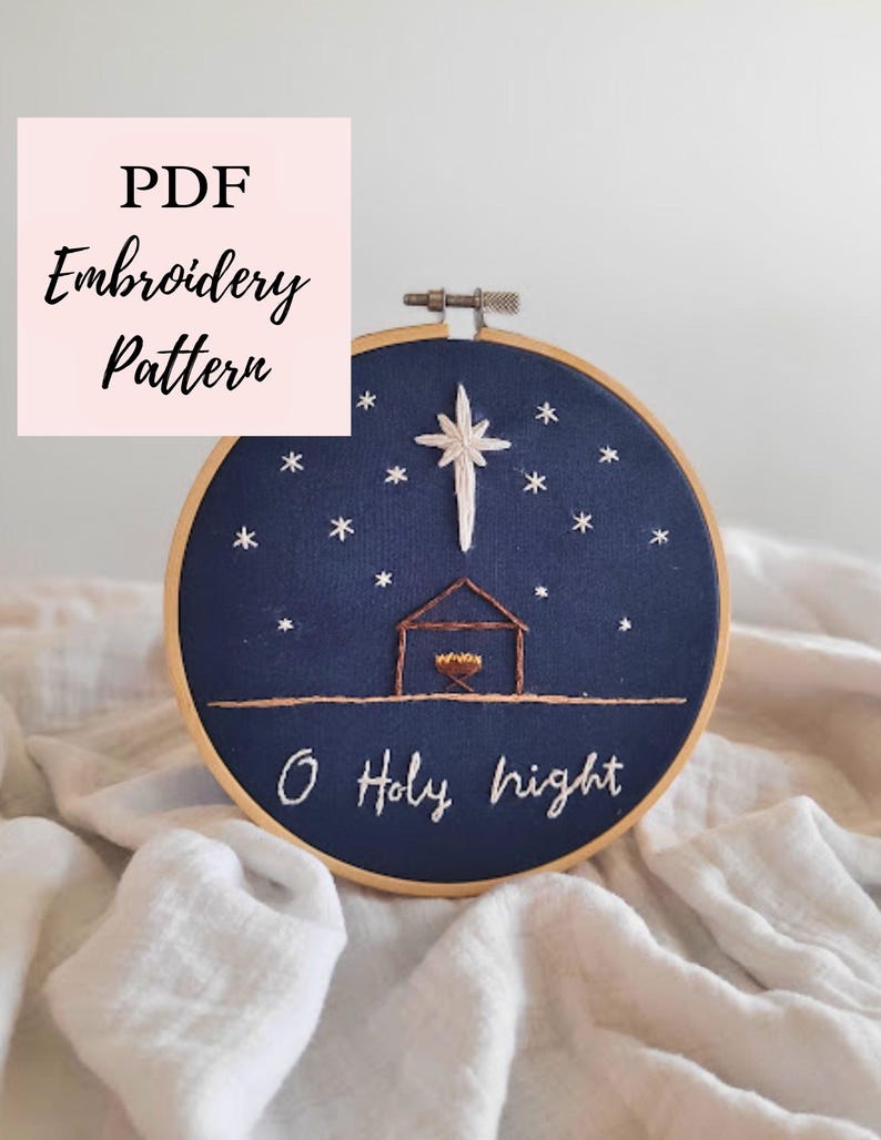 May include: A navy blue embroidery hoop with a Christmas scene. The design features a star, a stable, and the words "O Holy Night". The text "PDF Embroidery Pattern" is in a pink square.