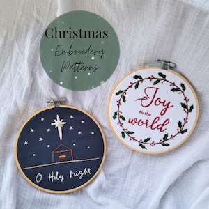 May include: Two Christmas embroidery patterns in wooden hoops. One depicts a nativity scene with a star and the text "O Holy night." The other says "Joy to the world" surrounded by a holly wreath. A green circle with the text "Christmas Embroidery Patterns" is in the background.