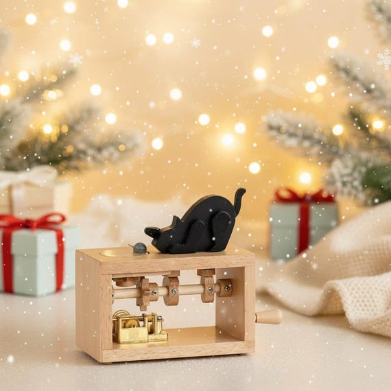 A hand-carved wooden automaton where a cat perpetually chases a mouse — a charming mechanical desk piece that's genuinely made by hand, not a factory.