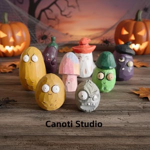 Puede incluir: Una colección de figuras de madera talladas a mano, caprichosas, con forma de verduras y hongos, con caras de dibujos animados. Incluye calabazas, berenjenas, setas y otros personajes únicos. El texto "Canoti Studio" está en la parte inferior.