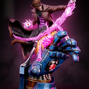 May include: A collectible statue of a character with brown hair wearing a brown trench coat and purple shirt, standing on a large blue robotic hand. The character holds a playing card surrounded by bright pink energy effects and lightning.