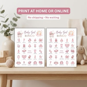 May include: Two rectangular paper game cards titled Baby Girl BINGO, featuring a grid of pink illustrations of baby items like rattles, onesies, and strollers. Each card includes a central Free Space and a moon graphic at the top right corner.