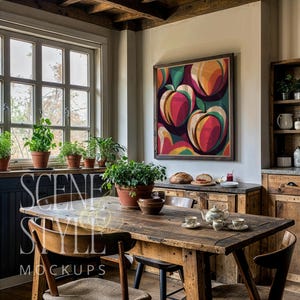 Puede incluir: Una escena de comedor rústico con una gran mesa de madera, sillas y una obra de arte enmarcada con un diseño de melocotones colorido. La habitación está llena de luz natural de una gran ventana y las plantas en macetas añaden un toque de vegetación. Las palabras "SCENE STYLE MOCKUPS" son visibles.