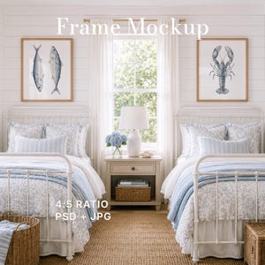 May include: Two white framed wall art prints featuring blue illustrations of a fish and a lobster, displayed above two twin beds with blue and white floral bedding, a white nightstand with a lamp, and a woven basket in a bright room.