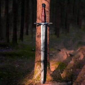 Puede incluir: Una espada larga y plateada con un mango marrón y una guarda cruzada decorativa se coloca contra un tronco de árbol en un bosque. La hoja de la espada es larga y recta, reflejando la luz. El mango es de color marrón oscuro y la guarda cruzada tiene detalles intrincados.