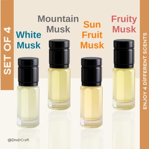 Puede incluir: Un juego de cuatro pequeños frascos de perfume con tapas negras, etiquetados como "White Musk", "Mountain Musk", "Sun Fruit Musk" y "Fruity Musk". Los frascos están llenos de un líquido amarillo claro. También se ve el texto "SET OF 4" y "ENJOY 4 DIFFERENT SCENTS".