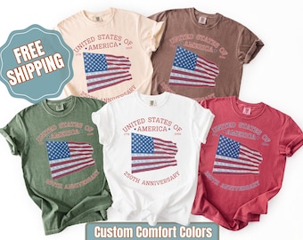 May include: A collection of short-sleeved t-shirts in various colors, each featuring a distressed American flag design. The shirts display the text "United States of America" and "250th Anniversary".