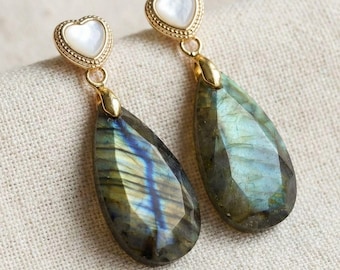 Gouden hartvormige oorknopjes met een druppelvormige hanger van labradoriet in een iriserende groenblauwe steen.