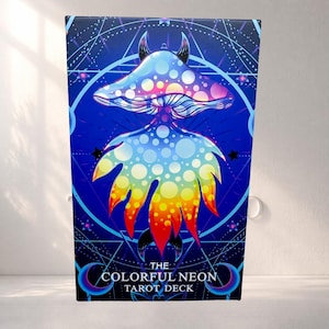 May include: A tarot deck box featuring a vibrant, psychedelic mushroom design in shades of blue, pink, yellow, and orange. The text "THE COLORFUL NEON TAROT DECK" is displayed at the bottom. The background includes geometric shapes and stars.