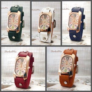 May include: Five wristwatches with different colored leather bands. Each watch has a rectangular face with a rose gold colored frame and a white face with colorful numbers. The watches are arranged in a grid pattern.