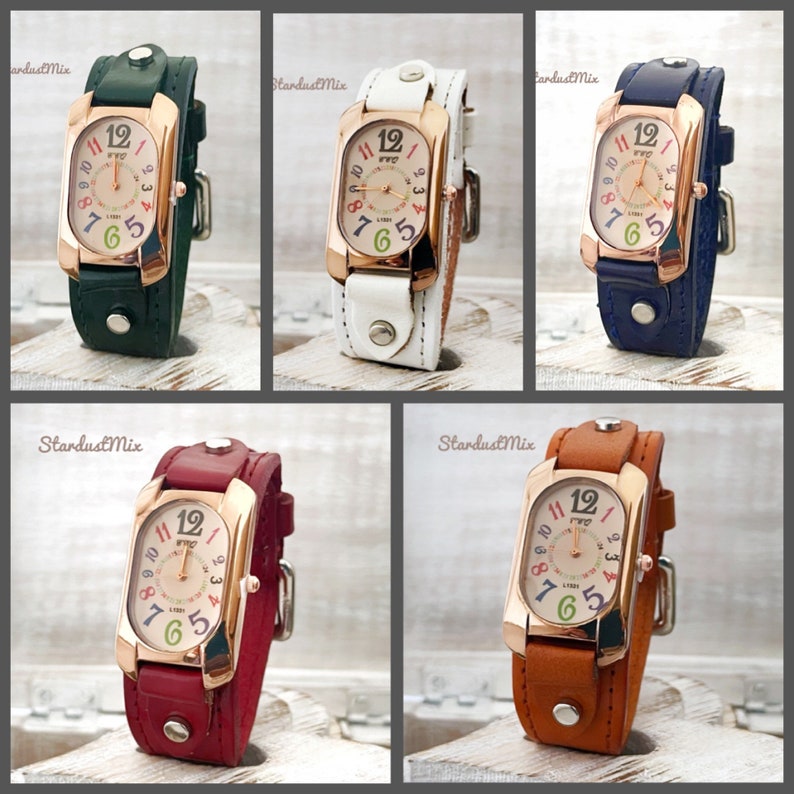 May include: Five wristwatches with different colored leather bands. Each watch has a rectangular face with a rose gold colored frame and a white face with colorful numbers. The watches are arranged in a grid pattern.