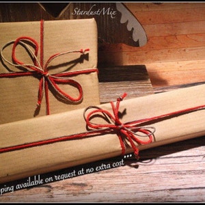 May include: Two brown paper packages tied with twine and red ribbon. The text "...Gift wrapping available on request at no extra cost..." is visible at the bottom of the image.