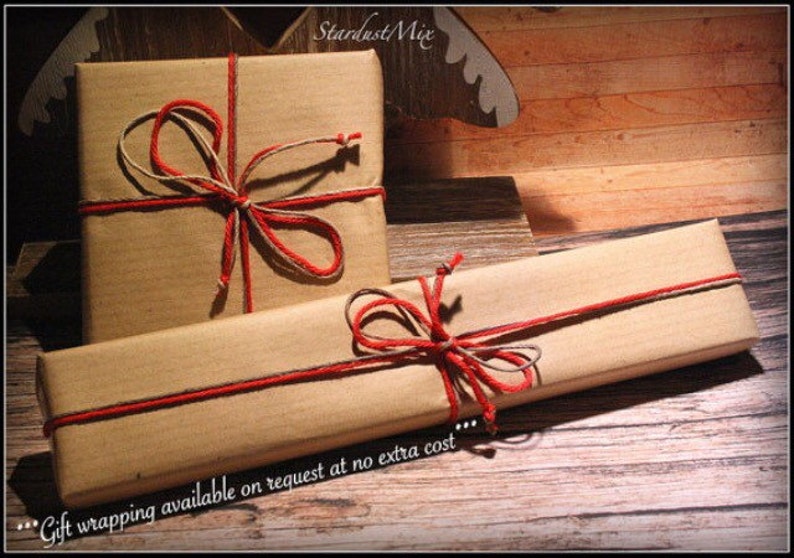 May include: Two brown paper packages tied with twine and red ribbon. The text "...Gift wrapping available on request at no extra cost..." is visible at the bottom of the image.