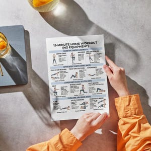 May include: A person holding a white printed workout guide titled "15-Minute Home Workout (No Equipment)". The guide features illustrated exercises for warm-up, upper body, lower body, and core workouts. The person is wearing an orange long-sleeved shirt.