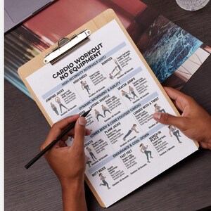 May include: A wooden clipboard holds a workout plan titled "Cardio Workout No Equipment." The plan includes exercises like jumping jacks, burpees, and skater jumps, with illustrations and duration times. A person is holding the clipboard and a pen.