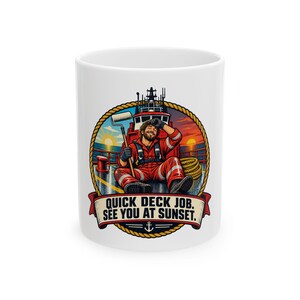 May include: A white ceramic mug featuring a circular graphic of a worker in a red jumpsuit sitting on a ship deck holding a paint roller. The background shows a sunset over the ocean and a ship. The text reads, "QUICK DECK JOB. SEE YOU AT SUNSET."