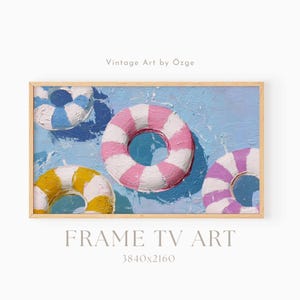 May include: A framed artwork featuring four colorful life preservers floating on a blue water background. The life preservers are painted in shades of pink, yellow, blue, and purple with white stripes. The text "FRAME TV ART" is at the bottom.