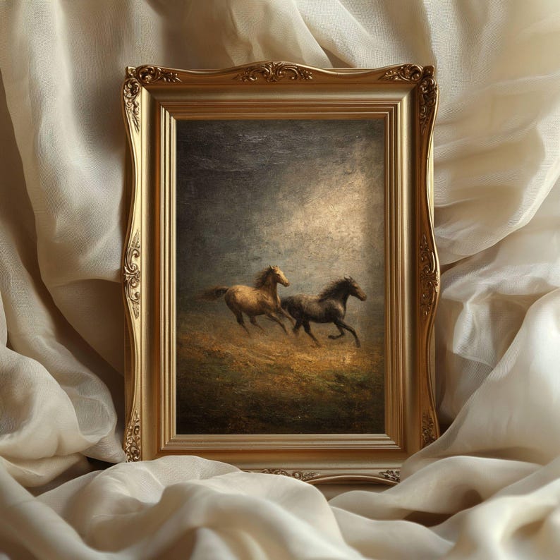 Op de afbeelding: Een goudomrand schilderij met twee paarden die over een veld galopperen. Het kunstwerk is geplaatst in een sierlijke gouden lijst. De paarden zijn bruin en zwart, tegen een donkere, sfeervolle achtergrond.
