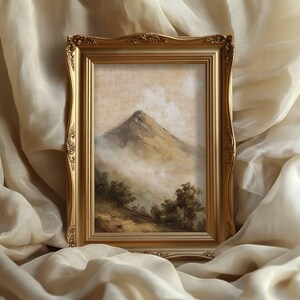 May include: A landscape painting in a gold ornate frame, depicting a mountain peak emerging from the mist. The artwork features a mountain with trees and a cloudy sky, rendered in muted earth tones. The frame has decorative detailing.