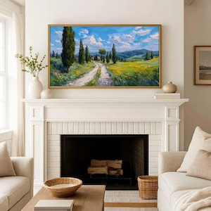 May include: A framed landscape painting depicts a winding dirt road through a field of yellow flowers and tall green trees under a blue sky with fluffy white clouds. The painting is displayed above a white fireplace.