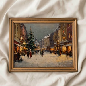 May include: A framed painting depicts a snowy Christmas scene. The artwork shows a street lined with buildings, a decorated Christmas tree, and figures walking. The painting is in a wooden frame.