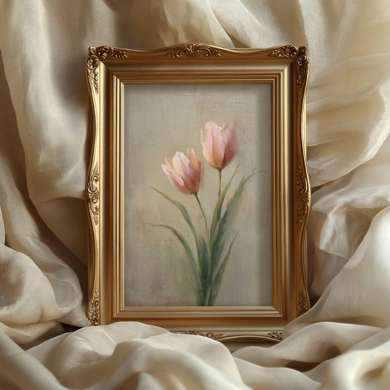 K&ouml;nnte beinhalten: Gerahmtes Gem&auml;lde mit zwei rosa Tulpen mit gr&uuml;nen Stielen und Bl&auml;ttern. Das Kunstwerk ist in einem goldenen, verzierten Rahmen eingefasst. Der Hintergrund ist in einem neutralen Beige gehalten.