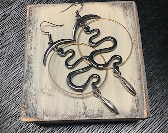 Pendientes colgantes de oro con círculo y dije de serpiente en color gris plomo para mujer. Estilo bohemio, hippie y étnico.