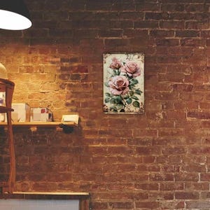 May include: A rectangular wall art print featuring a vintage-style illustration of pink roses with green leaves. The artwork has a distressed, aged appearance, with a cream-colored background and a decorative border. The print is mounted on a brick wall.
