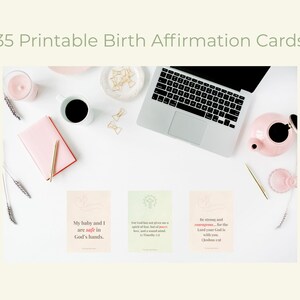 May include: An overhead shot of a workspace with a laptop, pink notebook, and a teapot. Three affirmation cards are displayed, with text that reads "My baby and I are safe in God's hands." The text "35 Printable Birth Affirmation Cards" is at the top.