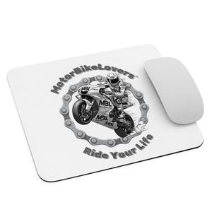 Può includere: Tappetino per mouse bianco con grafica motociclistica. Il design presenta un pilota di moto all'interno di un bordo a catena, con il testo "MotorBikeLovers" e "Ride Your Life". Un mouse per computer bianco è accanto al tappetino.