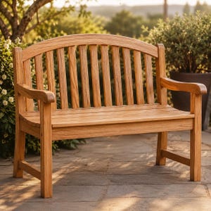 May include: A light brown wooden bench featuring a curved backrest with vertical slats, two armrests, and a flat seat. The bench is constructed with a natural wood grain finish and has four sturdy legs connected by horizontal support bars.