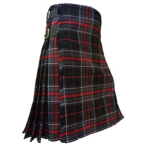 Pode incluir: Um kilt tradicional em um padrão xadrez preto, vermelho e cinza. O kilt apresenta tiras de couro com fivelas e bordas com franjas. O tecido tem um design tartan clássico.