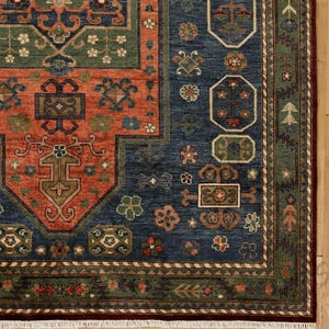 May include: Close-up of a section of a patterned rug. The rug features a deep blue field with geometric designs in shades of orange, green, and brown. The border is a mix of green and brown with floral motifs.