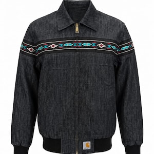 May include: A dark gray denim jacket with a black collar, cuffs, and hem. The jacket features a colorful embroidered design across the chest with red, turquoise, and white geometric patterns. A gold zipper and the Carhartt logo are visible.
