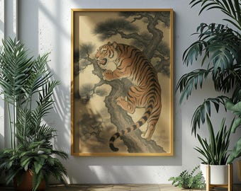 Puede incluir: Obra de arte enmarcada que representa un tigre trepando a un árbol. El tigre tiene rayas naranjas y negras, con una representación detallada de las ramas y hojas del árbol. La obra está en un marco dorado, expuesta contra una pared neutra, rodeada de plantas en macetas.
