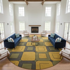 May include: A spacious living room with a modern design. Two navy blue sofas face each other, complemented by light-colored armchairs. A large, patterned rug in yellow, green, and gray dominates the floor. The room features a fireplace and large windows.