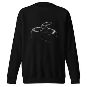 Puede incluir: Sudadera negra con una imagen en escala de grises de una serpiente enroscada. La serpiente es el foco principal, con escamas detalladas y una cabeza ligeramente levantada. El diseño está centrado en la parte delantera de la prenda de manga larga.