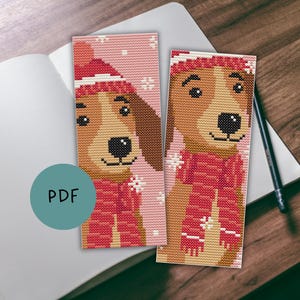 Op de afbeelding: Twee kruissteek bladwijzers met honden. Eén toont een hond met een rode hoed en sjaal op een roze achtergrond met sneeuwvlokkenpatroon. De andere bladwijzer heeft een vergelijkbaar ontwerp. Het woord "PDF" staat in een turquoise cirkel.