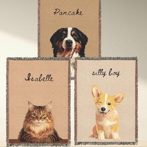 May include: Three beige throw blankets with fringed edges, each featuring a pet portrait and a name. The top blanket shows a Bernese Mountain Dog with the name "Pancake." The middle blanket has a cat named "Isabelle." The bottom blanket displays a winking corgi labeled "silly boy."