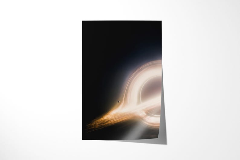 May include: A poster featuring a depiction of a black hole. The image shows a bright, swirling ring of light against a dark background. A small, dark sphere is visible near the center of the ring. The poster is rectangular and has a glossy finish.
